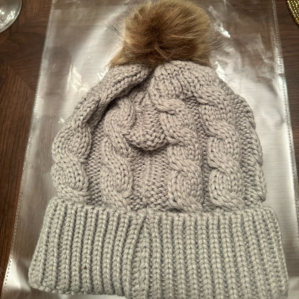 New in packaging. Women’s Grey Soft Puff Beanie. Perfect for the Coldness.